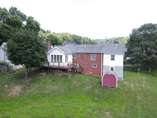 rear view of house with a wooden deck and a yard