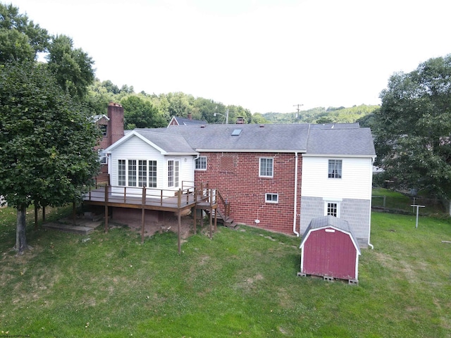 rear view of house featuring a lawn and a wooden deck