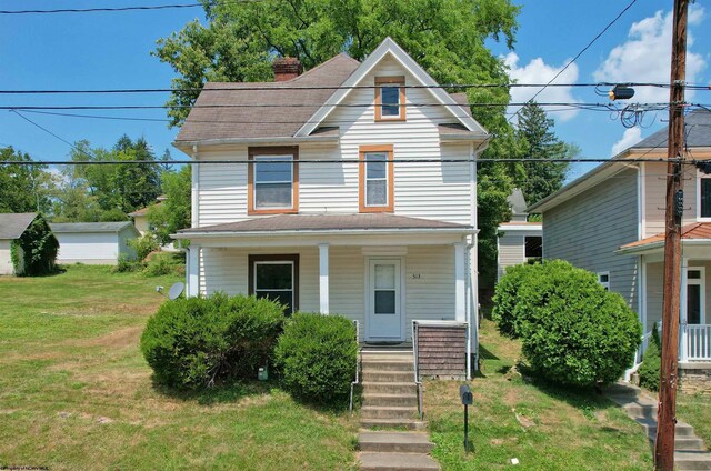 view of front facade featuring a garage, a front lawn, and covered porch