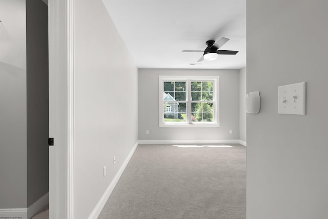 empty room featuring ceiling fan and light carpet