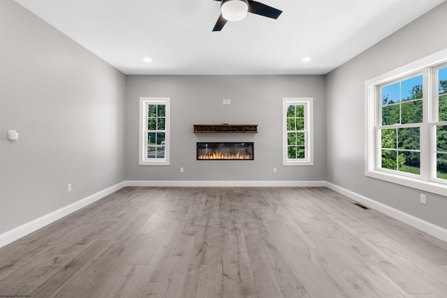 unfurnished living room featuring ceiling fan and light hardwood / wood-style flooring