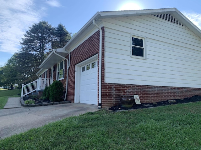 view of side of property featuring a garage and a lawn