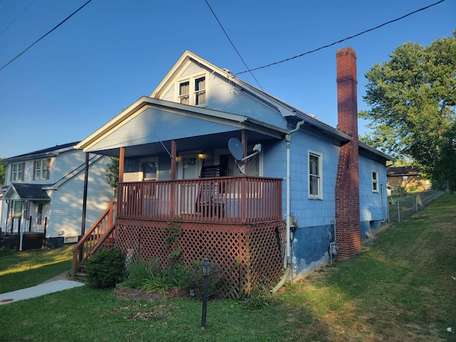 bungalow-style house featuring a front yard and a deck