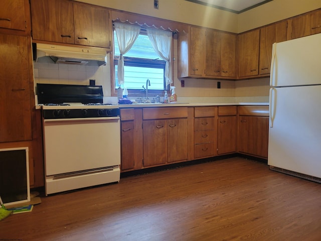 kitchen with tasteful backsplash, dark hardwood / wood-style flooring, sink, and white appliances