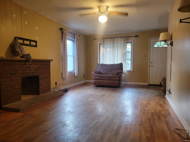 unfurnished room featuring crown molding, a fireplace, a wealth of natural light, and wood-type flooring