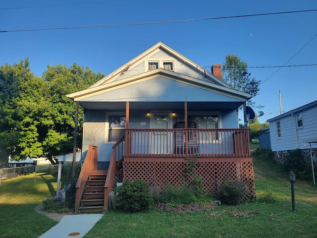 bungalow-style house with covered porch and a front lawn