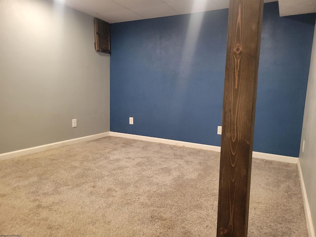 carpeted empty room with a paneled ceiling