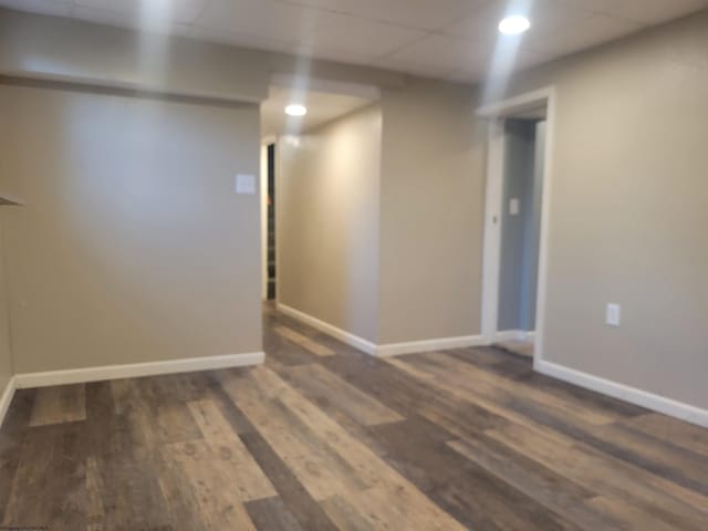 basement with dark hardwood / wood-style floors and a paneled ceiling