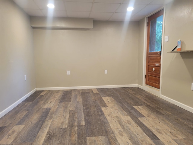 basement featuring dark hardwood / wood-style floors and a paneled ceiling