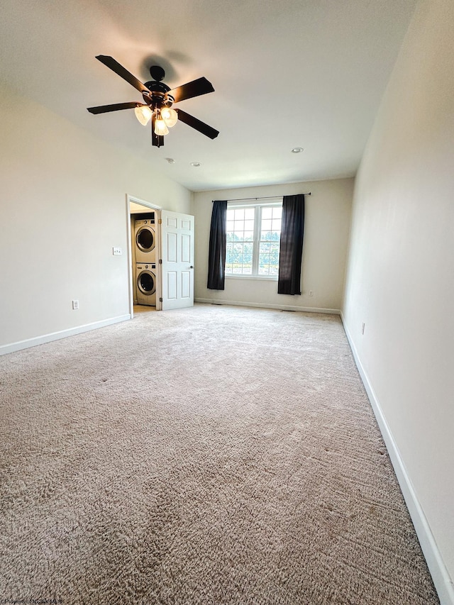 interior space with stacked washer / drying machine, carpet flooring, and ceiling fan