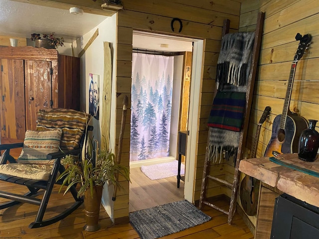 entryway with wooden walls and hardwood / wood-style floors