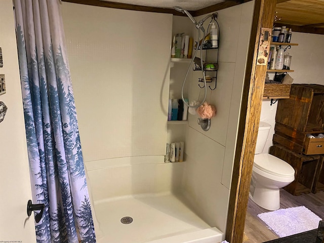 bathroom featuring toilet, wood-type flooring, and walk in shower