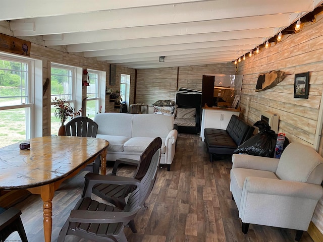 living room with wood walls, dark hardwood / wood-style flooring, lofted ceiling with beams, and track lighting