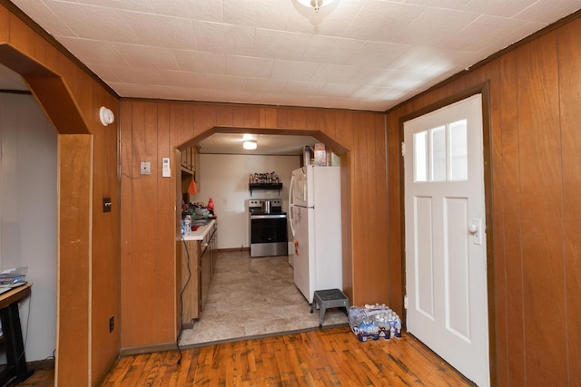 foyer entrance with wooden walls and light hardwood / wood-style floors