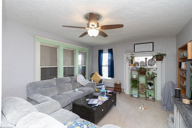 living room with ceiling fan, light colored carpet, and a textured ceiling