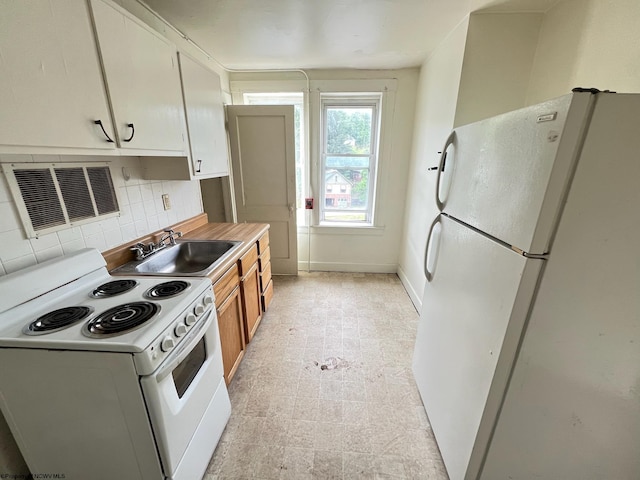 kitchen featuring white cabinetry, tasteful backsplash, white appliances, light tile patterned floors, and sink