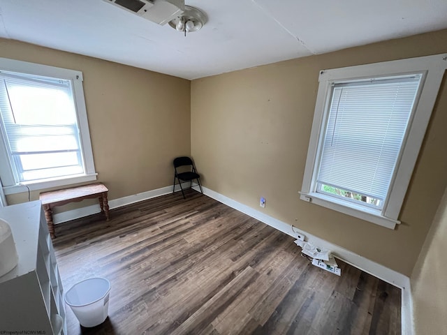 empty room with a healthy amount of sunlight, hardwood / wood-style floors, and ceiling fan