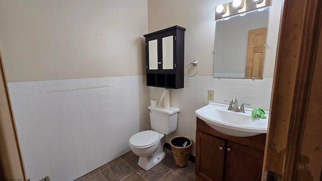 bathroom with toilet, vanity, tile walls, tile patterned floors, and decorative backsplash