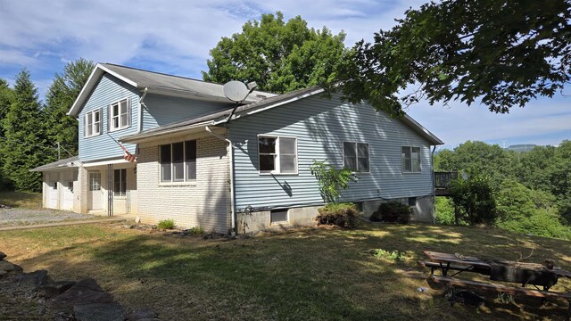 view of side of property featuring a garage and a lawn