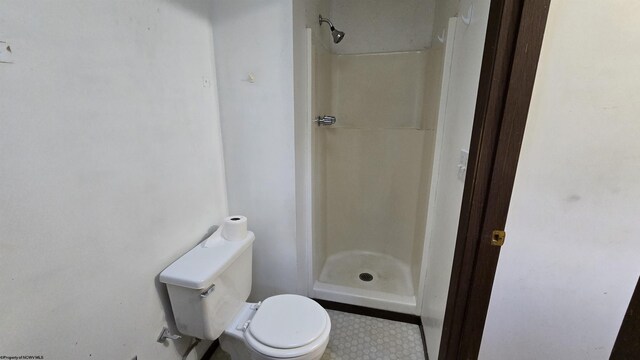 bathroom with walk in shower, toilet, and tile patterned floors