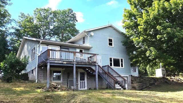 rear view of property featuring a yard and a wooden deck