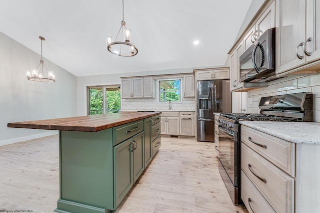 kitchen with a kitchen island, butcher block counters, hanging light fixtures, green cabinets, and gas range