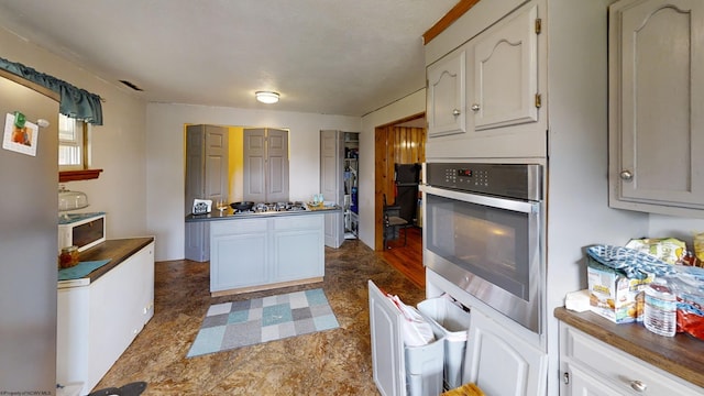 kitchen with stainless steel gas cooktop, white cabinetry, and tile patterned flooring