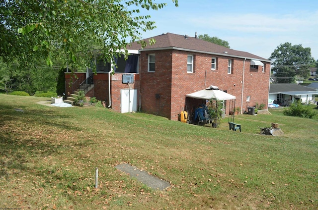 view of side of home with a yard and a gazebo