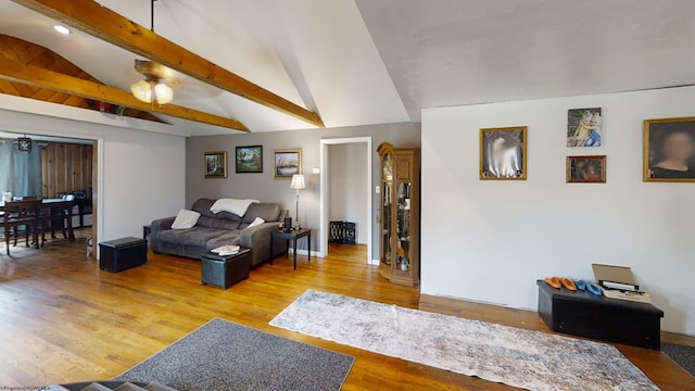 living room with vaulted ceiling with beams and light hardwood / wood-style flooring