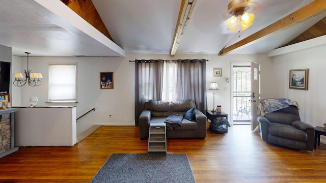 living room featuring vaulted ceiling with beams, ceiling fan with notable chandelier, wood-type flooring, and a healthy amount of sunlight