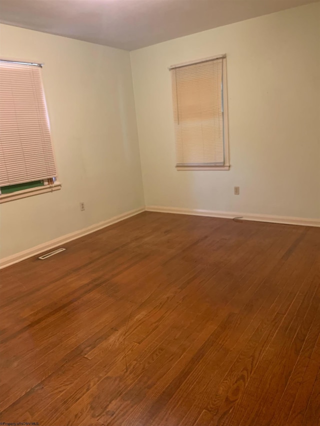 empty room with dark wood-type flooring