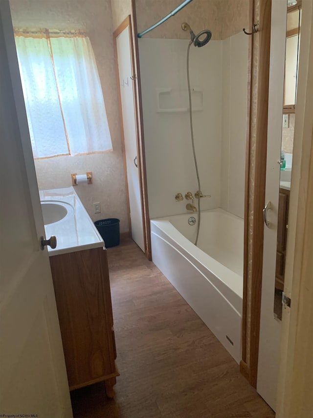 bathroom with wood-type flooring, shower / bath combination, and vanity