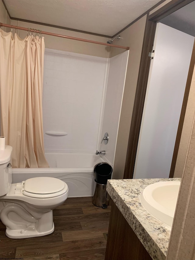 full bathroom with a textured ceiling, vanity, toilet, shower / tub combo with curtain, and hardwood / wood-style flooring