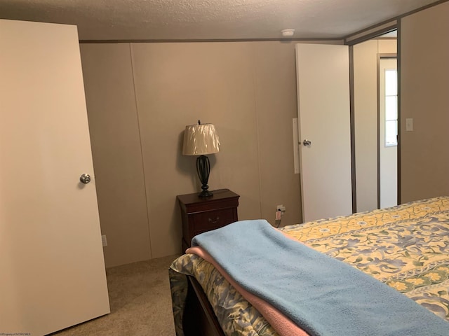 bedroom with a textured ceiling and light colored carpet