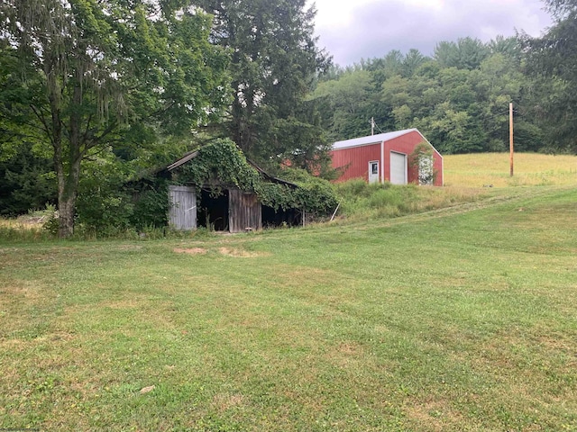 view of yard with a garage and an outbuilding