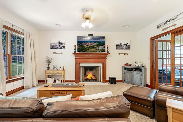 living room featuring ceiling fan, a wealth of natural light, light colored carpet, and french doors