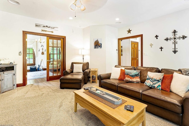 living room with light carpet, french doors, and ceiling fan