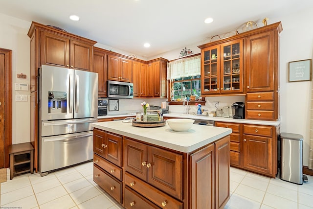 kitchen featuring light tile patterned flooring, appliances with stainless steel finishes, a kitchen island, and sink