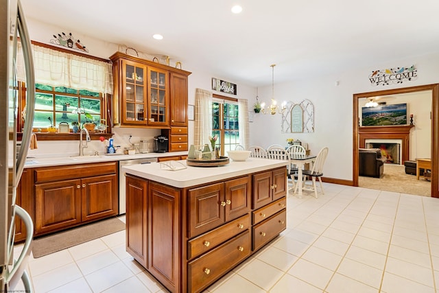 kitchen featuring pendant lighting, a center island, sink, a chandelier, and light tile patterned floors