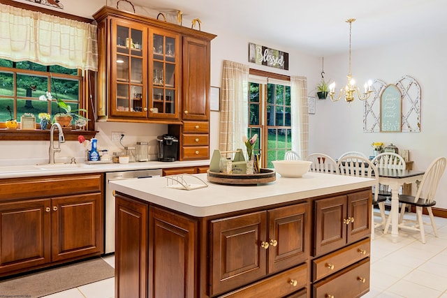 kitchen with sink, hanging light fixtures, a notable chandelier, light tile patterned flooring, and stainless steel dishwasher