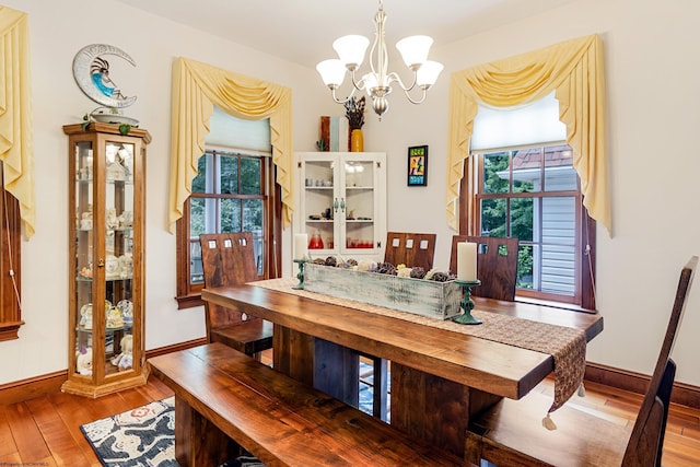 dining space featuring hardwood / wood-style flooring and a notable chandelier