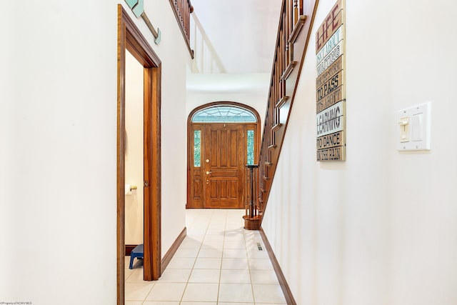 interior space featuring a towering ceiling and light tile patterned flooring