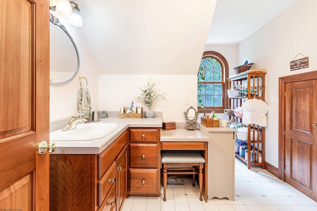 bathroom with vanity, vaulted ceiling, and tile patterned floors