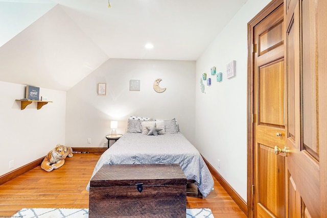 bedroom with vaulted ceiling and light wood-type flooring