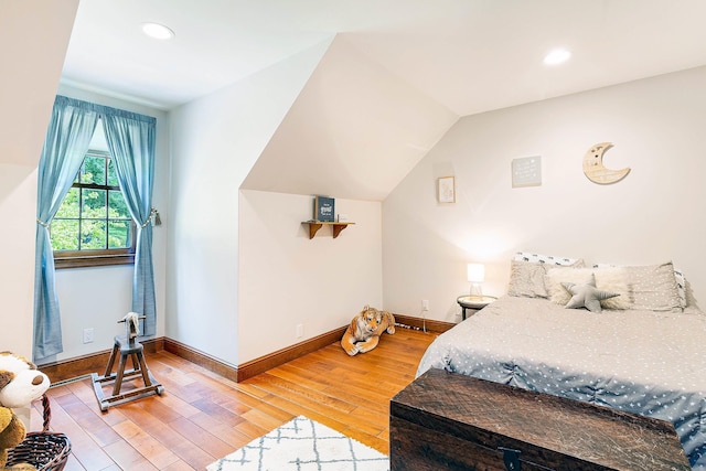 bedroom with hardwood / wood-style flooring and lofted ceiling