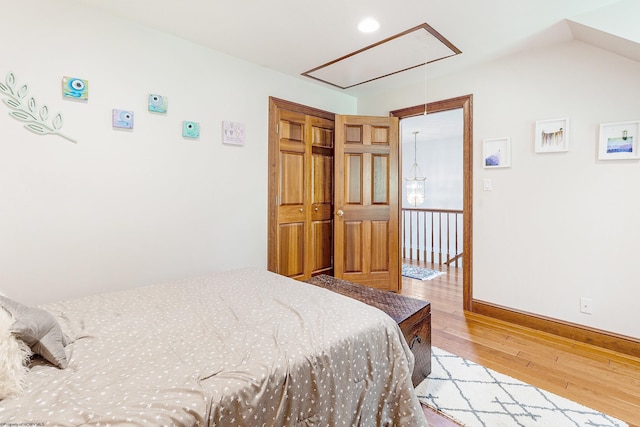 bedroom featuring light hardwood / wood-style floors and vaulted ceiling