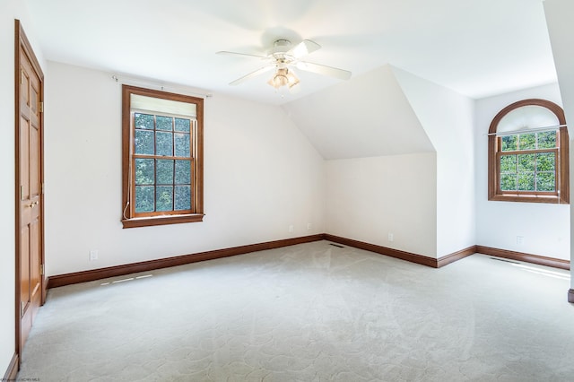 additional living space with lofted ceiling, ceiling fan, and light carpet