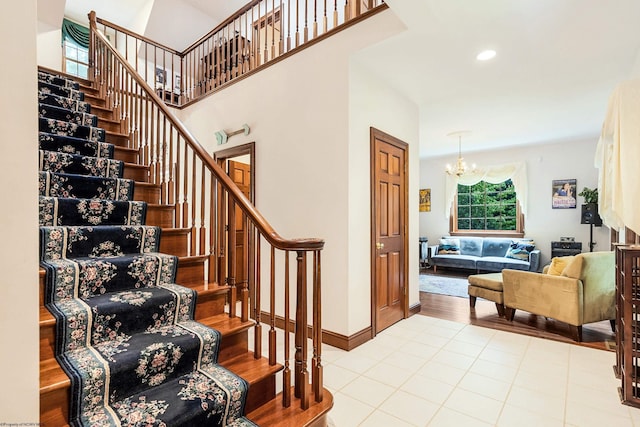 stairway with tile patterned flooring and an inviting chandelier