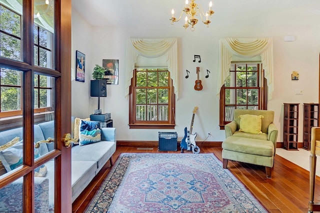 living area featuring wood-type flooring and an inviting chandelier