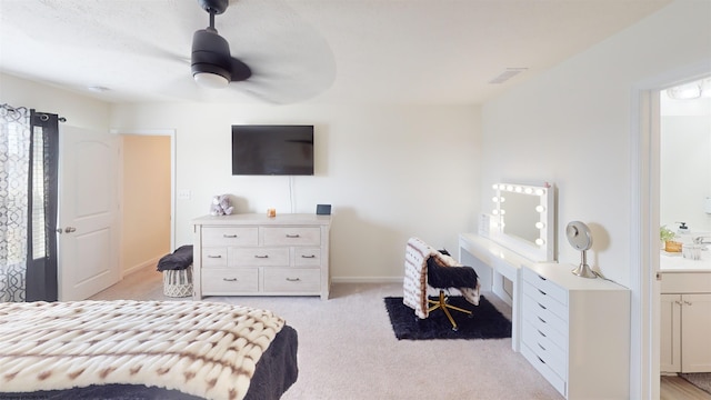 carpeted bedroom with ceiling fan, sink, and ensuite bath